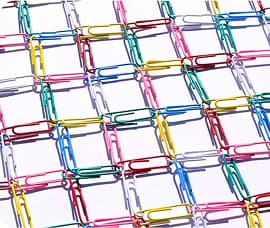 A grid of interlinked paper clips in assorted bright colors arranged on a white background.