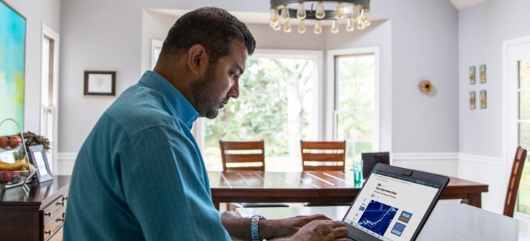 Man sitting at laptop viewing options information in a residential setting