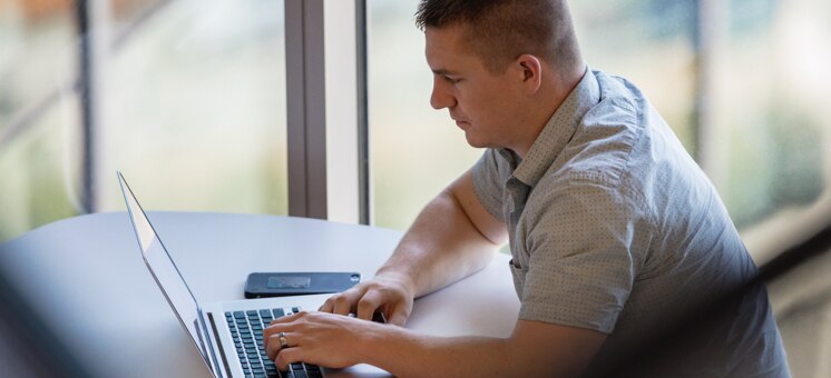 Man sitting in front of his laptop at a desk