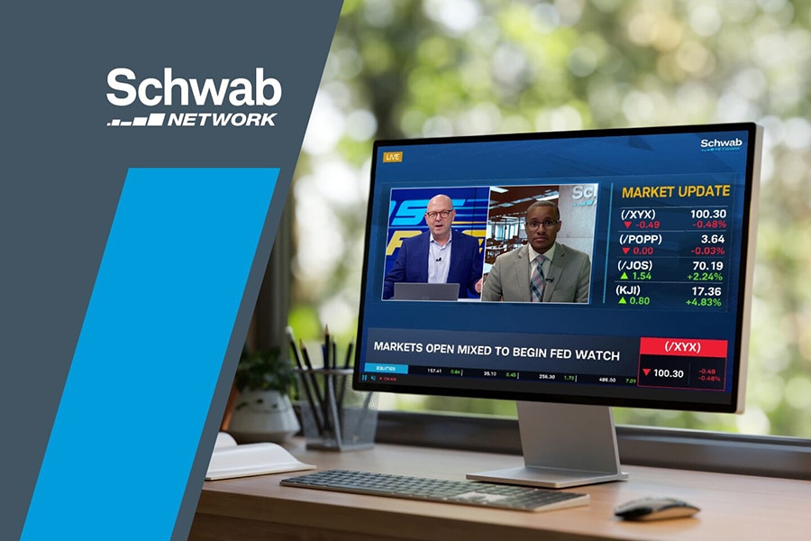 A computer monitor shows Schwab Network's live stream.