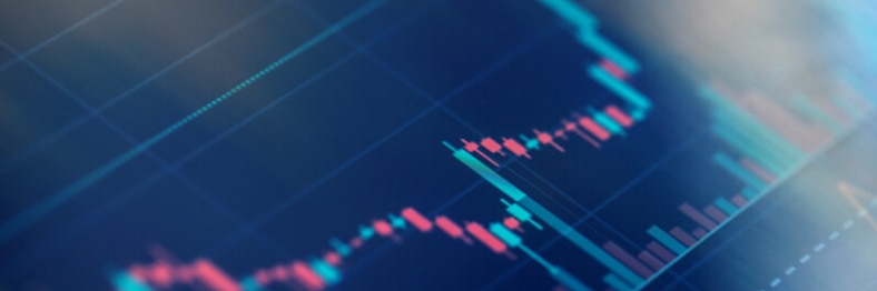 Photo of a candlestick chart on a digital screen.