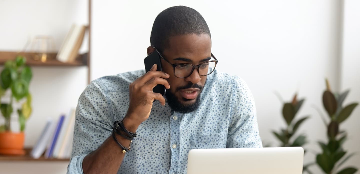 Investor on phone looking at laptop