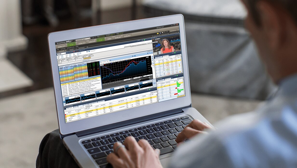 Person sitting with laptop looking at trading platform on screen