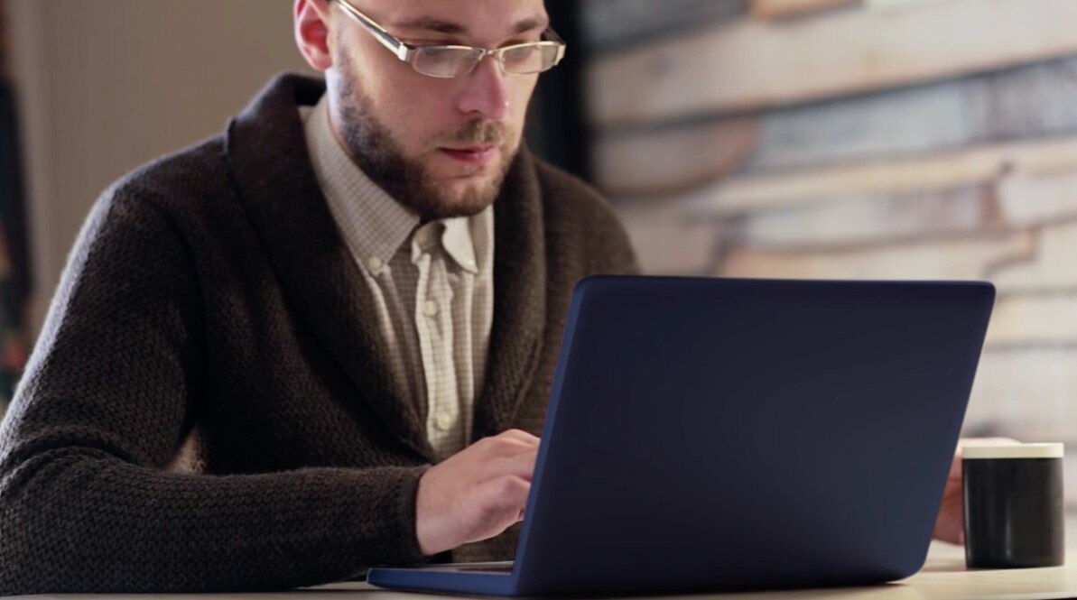 Screenshot of the Get help building a diversified portfolio video showing an investor looking at a laptop