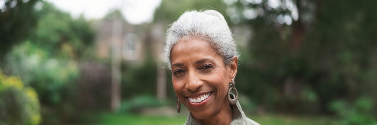 Rose, a woman in her 60s, smiles while standing outdoors.