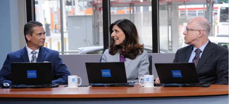 Schwab Live Daily cast sitting at a table with laptops and coffee mugs