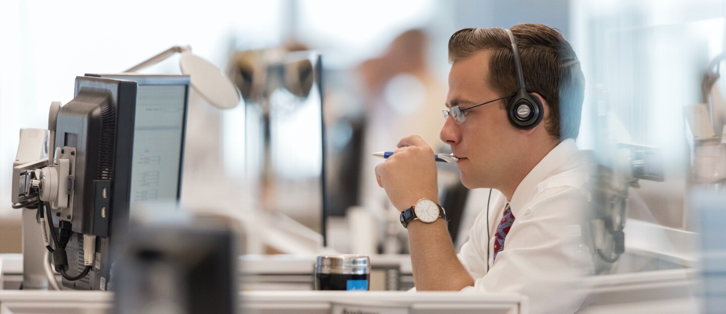 Options specialist at desktop wearing a headset