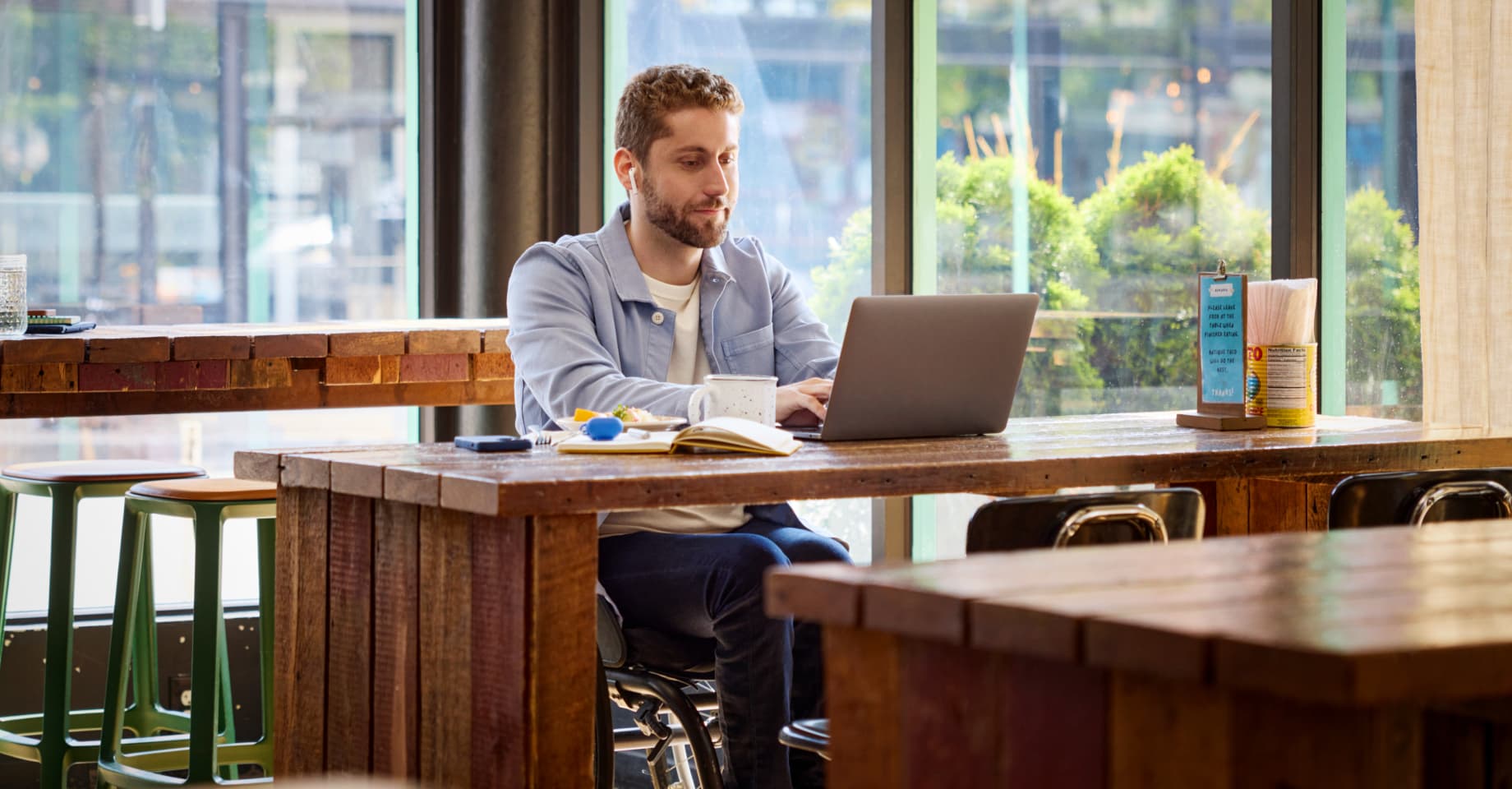 A man on his laptop sitting at a table. 