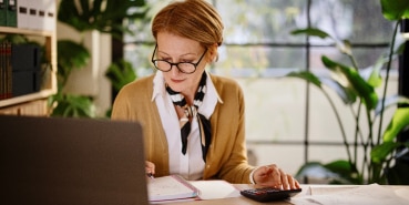 Woman doing accounting on a laptop.