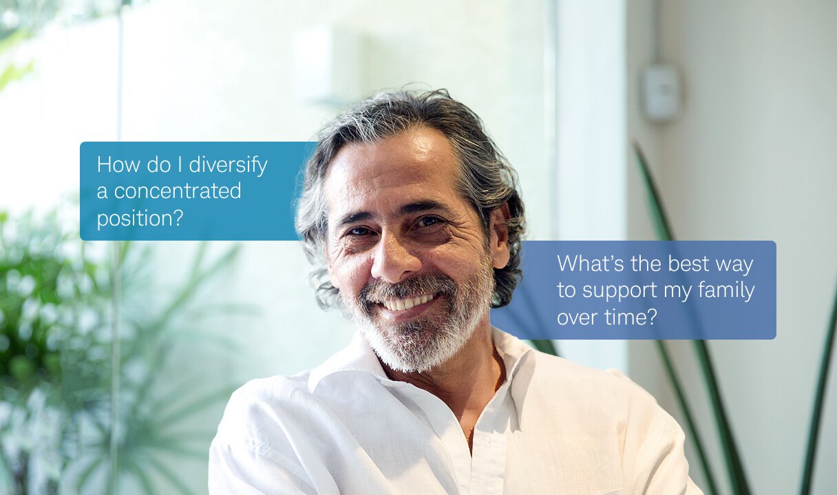 A man smiles while crossing his arms. Speech bubbles beside him read: “How do I diversify a concentrated position?”, “What’s the best way to support my family over time?”