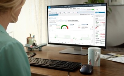 A woman with a desktop at a desk looking at tools and resources
